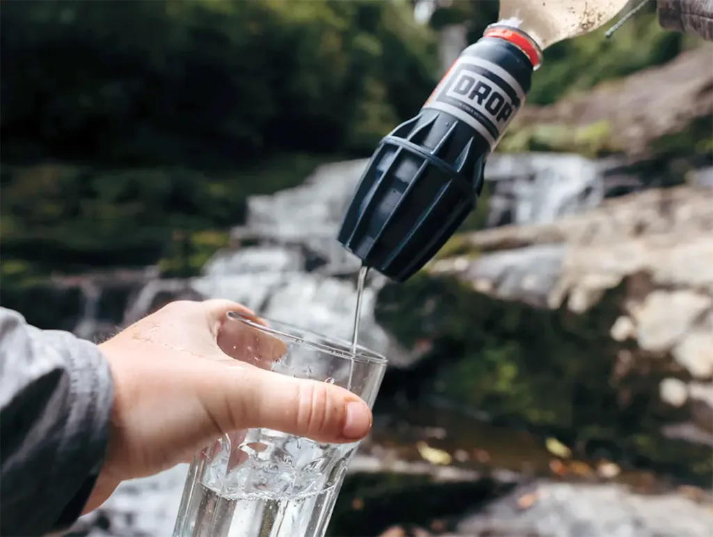 A hand made water filter puts water into a glass