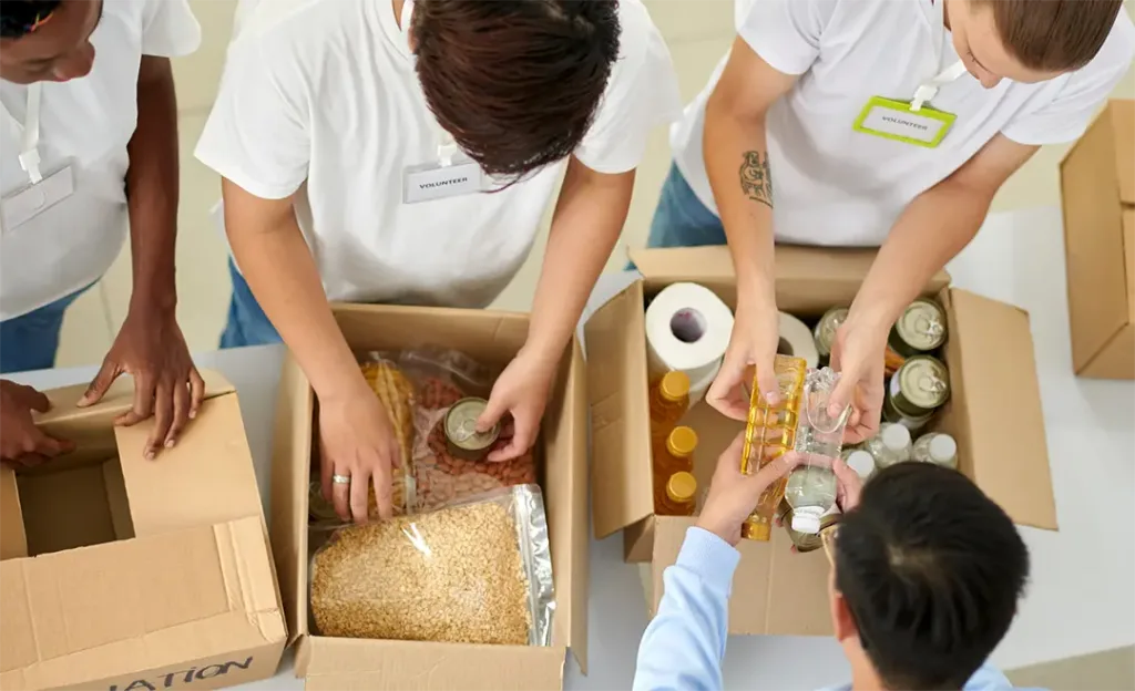 people work packing boxes of bagged food to give to the hungry