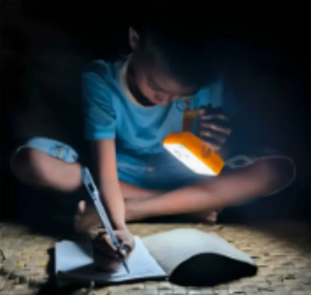 a child does homework at night using a Solar Buddy