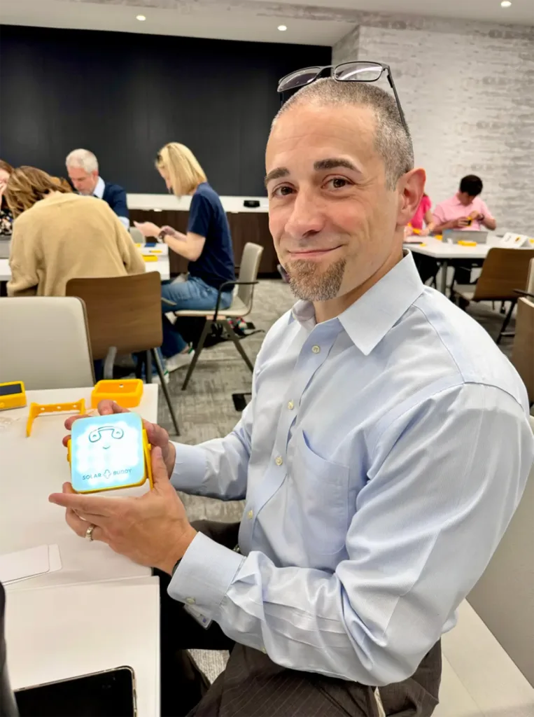 a man hold a solar buddy he just made